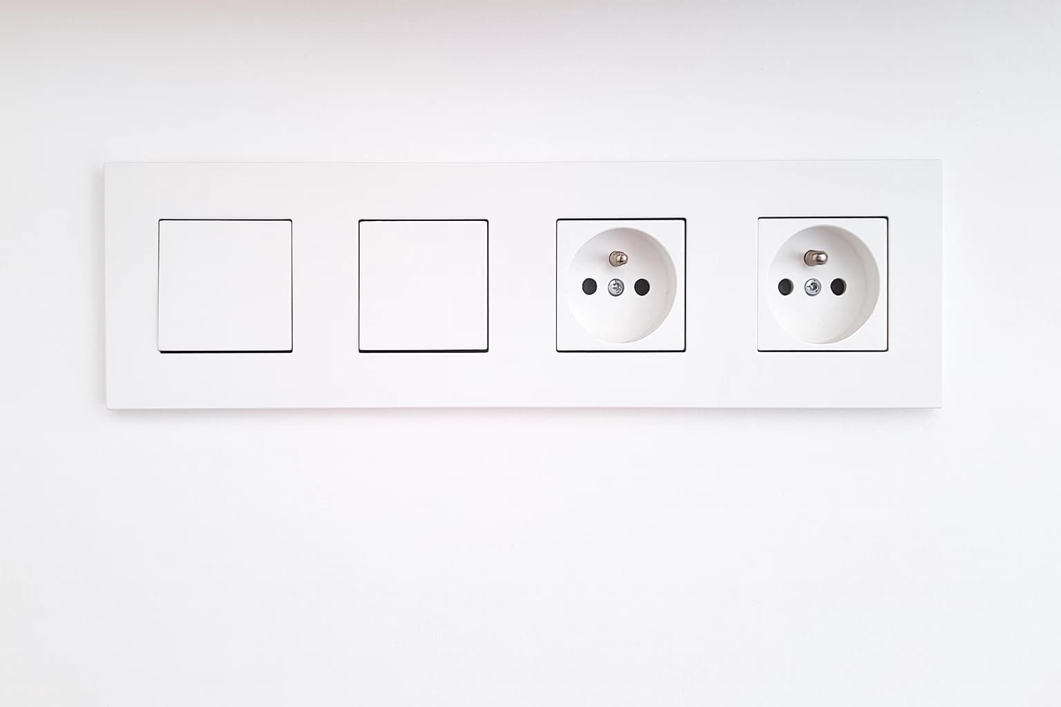 Moderné biele zásuvky a vypínače nainštalované na stene po výmene elektroinštalácie